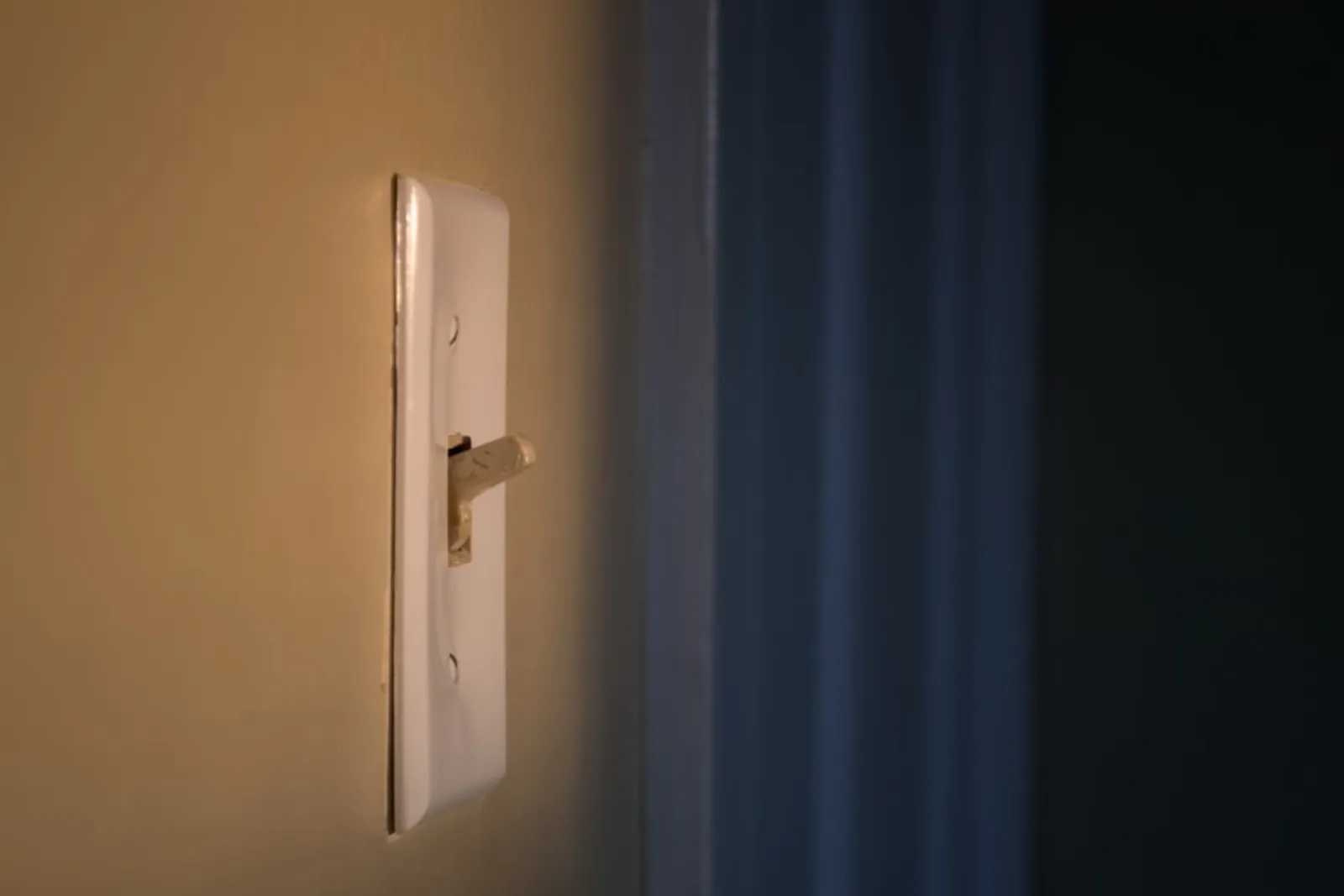 Spänningsprovare mot kablar bakom strömställare i väggdosa